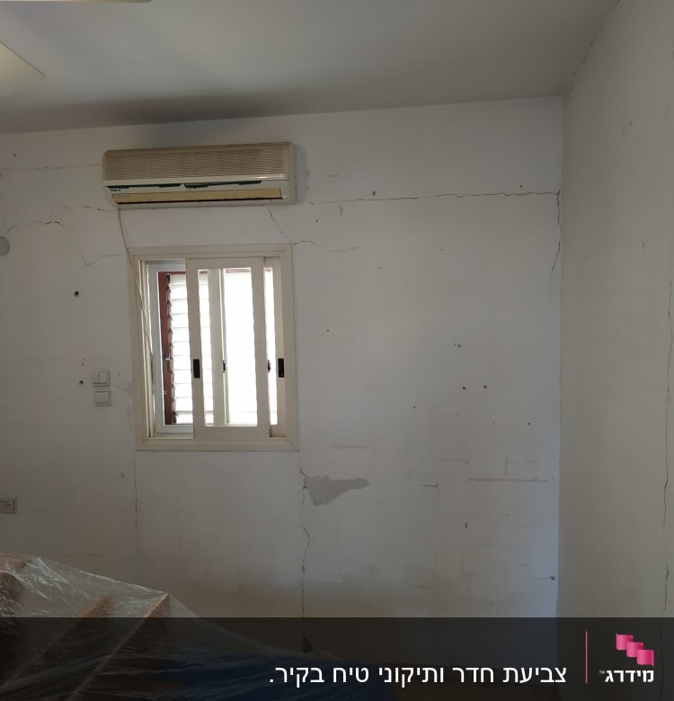 קיר עם סדקים, מכוסה בניילון לקראת צביעה